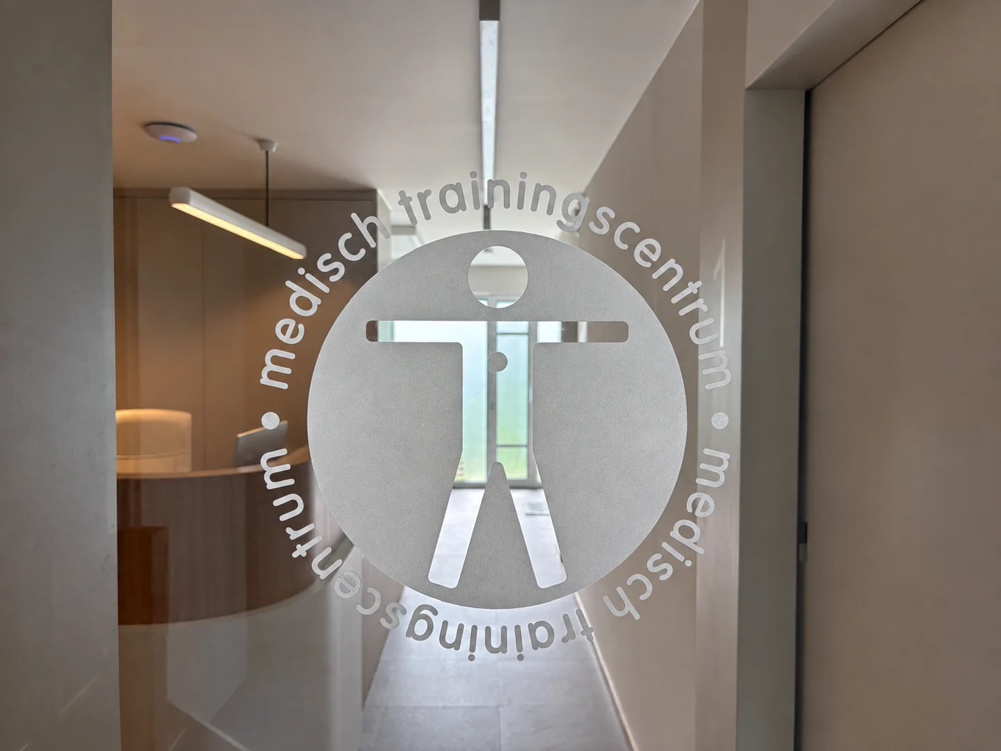 MTC-logo op het glas met de vernieuwde receptiebalie op de achtergrond